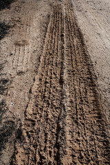 Tyre track on dirt sand or mud, Picture in retro or grunge tone. Car drive on sand. off road track. Track on grass field. Track in farm.