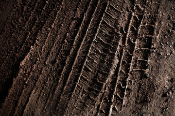 Tyre track on dirt sand or mud, Picture in retro or grunge tone. Car drive on sand. off road track. Track on grass field. Track in farm.