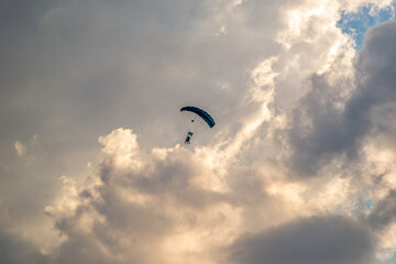 parachutists descending in the cloudy sky
