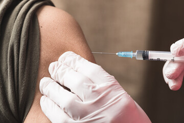A hand holding the syringe to give the patient the injection. Covid-19 or coronavirus vaccine