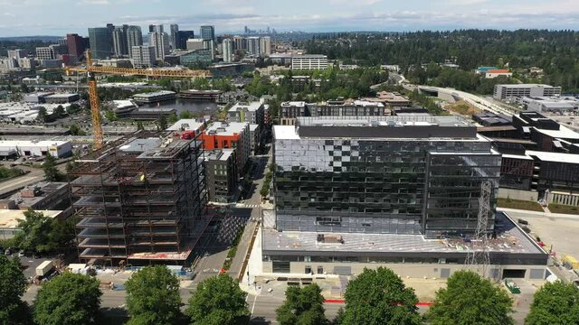 Cinematic drone footage of the new Spring District under construction in Bellevue, Washington downtown with residential and commercial high-rise buildings along Interstate highway 405 in King County