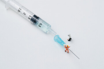 Miniature workers with a syringe that contains product to be injected