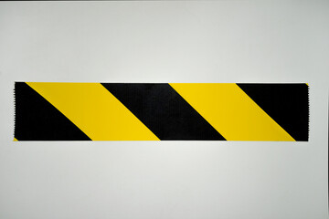Black and yellow stripe from the warning tape on the white isolate