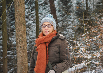 Portrait of a mid-aged woman wearing glasses in front of snowy winter landscape