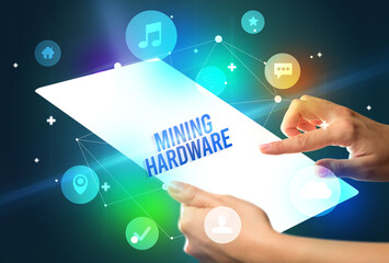 Holding futuristic tablet with MINING HARDWARE inscription, new technology concept