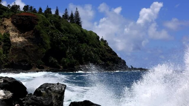 Waves crush on the rocks on the pacific island pitcairn shore