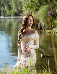 Beautiful girl model in a dress in the water on the river