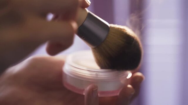 Makeup artist mixes powder with brush. Glitter makeup close-up