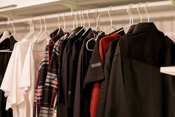 Many blouses,shirts on hangers in the dressing room.Modern wardrobe with stylish spring clothes and accessories.Rack with different clothes in a shop or home closet