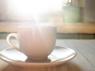 A cup on the table in the sunlight.