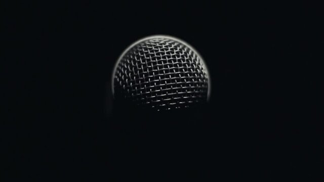 Light slowly rotating around microphone in darkness