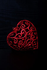 red decorative heart on black background, vertical