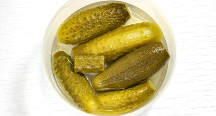 Homemade Pickled cucumbers with brine in a disposable container. Snack with vodka.