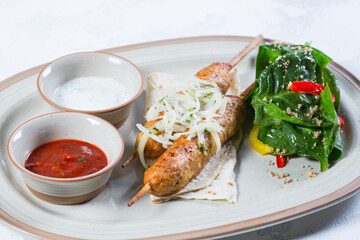 Lula-kebab of chicken with onions and hot red sauce.