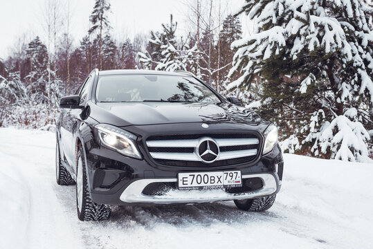 MOSCOW, RUSSIA-JANUARY 10, 2021: A black Mercedes Benz GLA 250 luxury crossover makes its way through snowdrifts in a snowy winter forest.