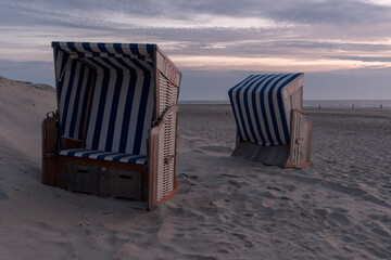 beach chairs in the sunset on Norderney island at the North Sea, Germany