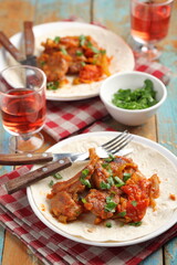 Lamb chops with tomato and pepper served with greens and red wine