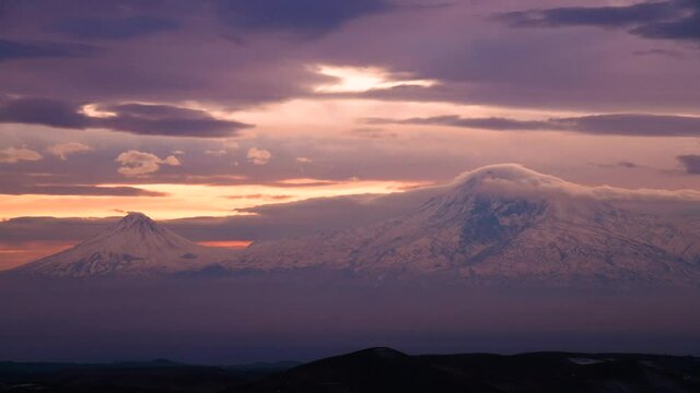 Beautiful sunset sky above clouds, dramatic sunset sky. Panoramic view on the mountains. Time Lapse clouds on the sunset.