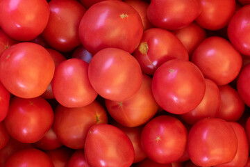 Pile of red fresh tomatoes, top view.