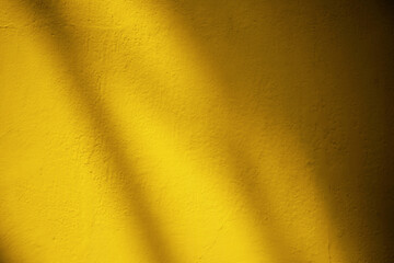 Light Beam and Shadow on the Surface of Fortuna Gold Color Wall Texture for Background with Space for Text.