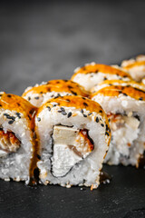 appetizing sushi roll california with eel tofu sesame and unagi cheese on a black stone plate