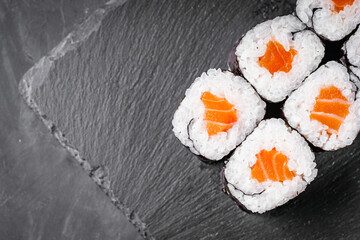 appetizing sushi roll maki with salmon on a black stone plate © Narsil