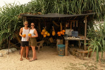 young couple buying coconuts at a beach in Sri Lanka