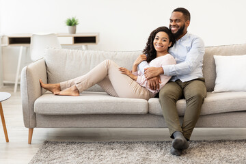 Fototapeta premium African american couple spending weekend together lying on couch