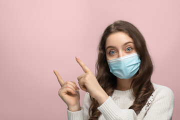 A young girl with long hair in a medical mask points to the corner of the screen with two fingers. Banner on the site.