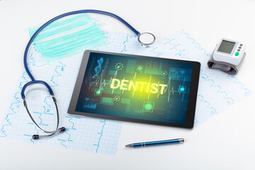 Tablet pc and medical stuff with DENTIST inscription, prevention concept