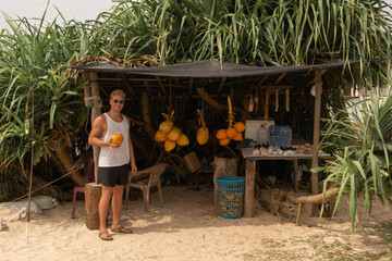 young man buying a coconut in Sri Lanka