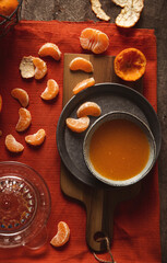 freshly squeezed tangerine juice in glass on rustic wooden background