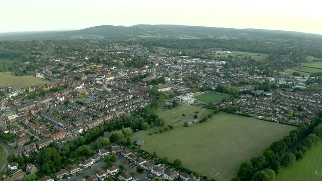 Cinematic drone aerial footage of beautifu classicl English Town in countryside, with old church in frame