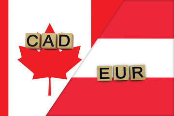 Canada and Austria currencies codes on national flags background