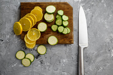 Obraz na płótnie Canvas Cutted lemon and cucumber on grunge background