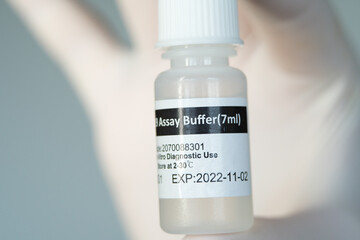 Covid-19 assay buffer sample to detect coronavirus via Antigen test. The bottle with the liquid is...
