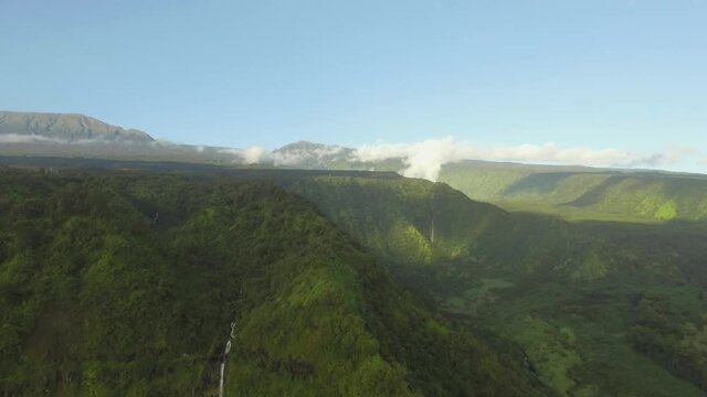 Aerial drone pull out shot of waterfall in jungle in hawaii