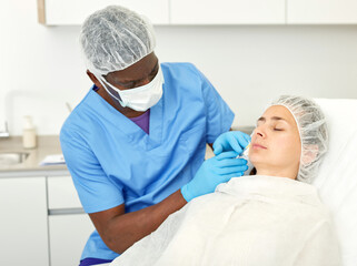 Portrait of woman client and doctor during beauty facial injections in medical esthetic office