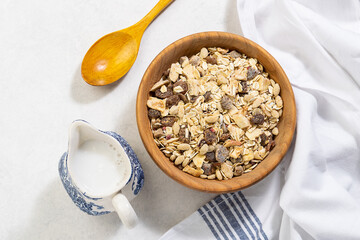Homemade granola with dry fruits and almond milk on white marble kitchen table top view. Healthy diet food concept. Tasty muesli for breakfast.