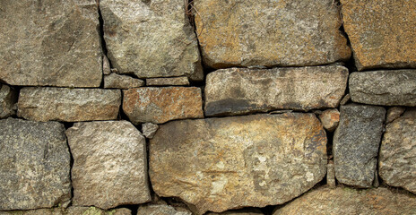 A stone wall made of cobblestones background for texture.