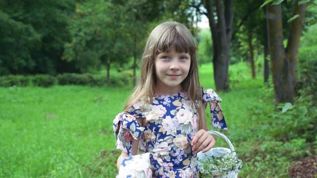 cute little girl with a basket dances in nature