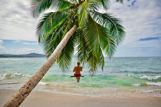 young man on a swing at a beach in Costa Rica