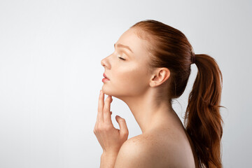 Side-View Of Sensual Shirtless Ginger-Haired Young Lady Over White Background