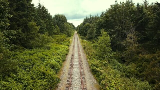 Forward facing drone view flying over old railroad tracks.
