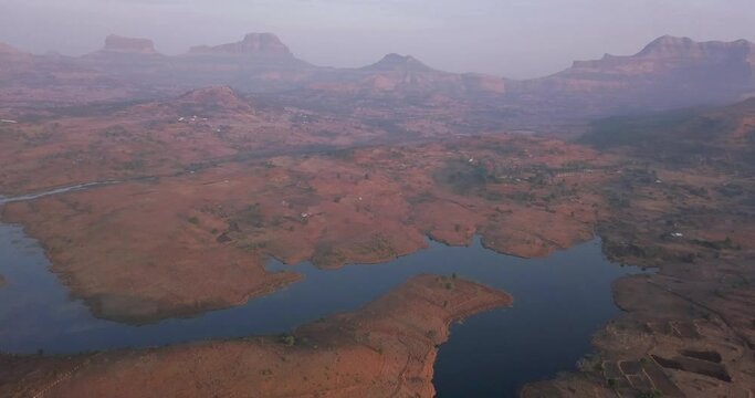 Beautiful red mountain landscape of Trimbakeshwar by the Vaitarna Dam Reservoir in Western Ghats of India -aerial