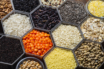 Food background of various cereals and grains in the hexagonal honeycomb jars