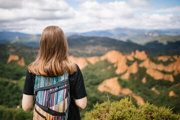 Unrecognizable alternative woman looking at the mountain landscape