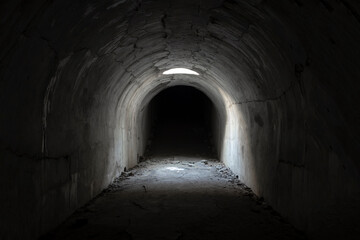Obraz premium A sunlit exit from a dark dungeon. Light at the end of the tunnel, exit from the underground passage.
