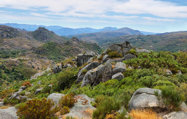 View of green mountains and stones from the ruins of Castro Laboreiro castle in Portugal