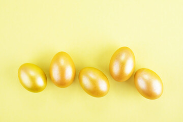 Bright gold and multi-colored colored eggs on a yellow background. Easter theme, holiday. Happy easter card with copy space for text in minimalist easter style.
Yellow, gold. Happy Easter